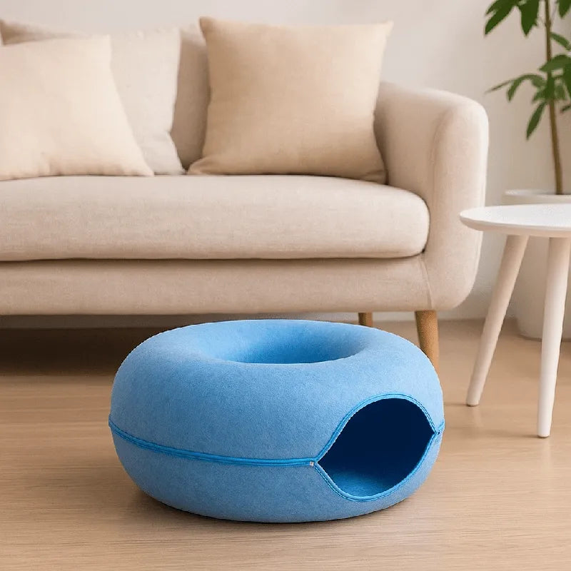 Coussin chat en feutre bleu placé dans un salon confortable