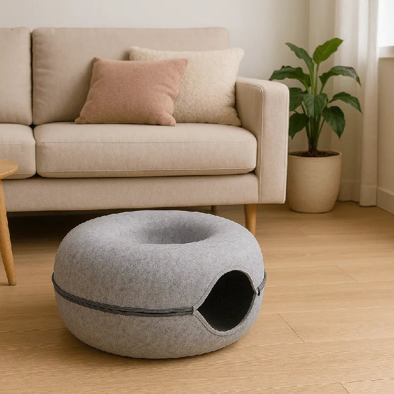 Coussin chat en feutre gris placé dans un salon moderne