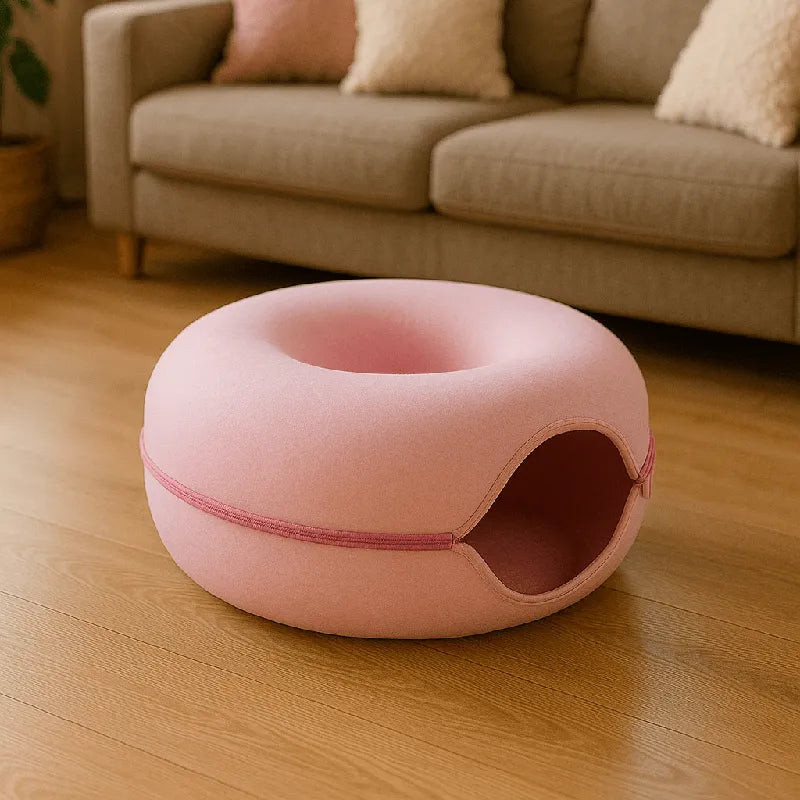 Coussin chat en feutre rose posé dans un salon moderne