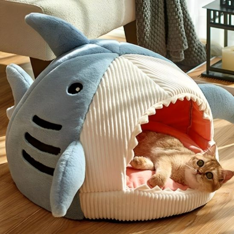 niche pour chat intérieur bleu en forme de requin avec un chat couché