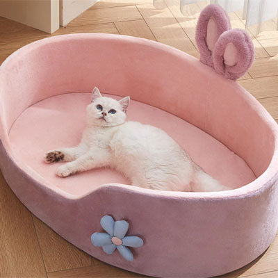 panier pour chat rose avec un chat blanc couché
