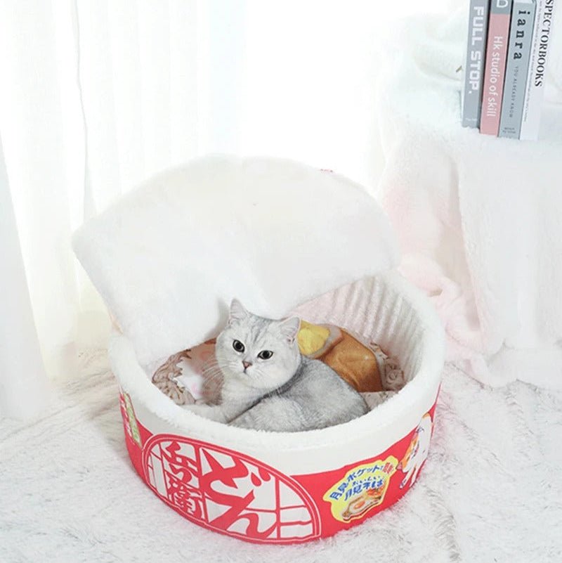 Chat gris dans une maison pour chat en forme ramen